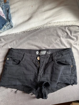 Svarta jeans shorts - Svarta jeans shorts i strl 152 men stretchiga. Lågmidjade och korta Midjemått 34