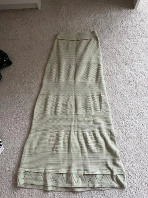 Ljusgrön  stickad långkjol - Snygg ljusgrön stickad långkjol med diskret mönster och dekorativ kant längst ner. Kjolen har en rak passform och är perfekt för dig som gillar en chill och stilren look. Passar till både sneakers och boots.