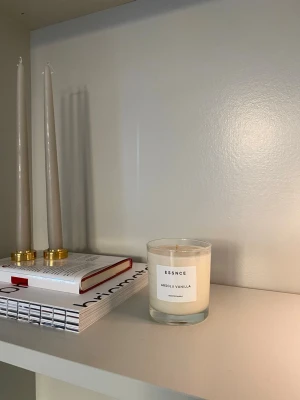 Doftljus Essnce - Oanvänt doftljus från Essnce, ABSOLU VANILLA. Doftar vanilj som kombineras av söta noter av brunt socker, tonkabönor, amberwood och patchouli.   Brinntid: upp till 40 timmar Material: 100% sojavax Vikt: 200g Mått: Höjd 8 cm Diameter 7,5 cm