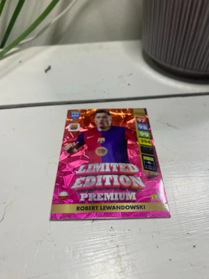 Limited Edition Premium samlarkort - Säljer ett Limited Edition Premium samlarkort från FIFA 365 med Robert Lewandowski. Kortet har en glansig rosa och guldig yta, med tryck i flera färger och tydliga stats på sidan. Perfekt för dig som gillar fotboll och samlarkort.
