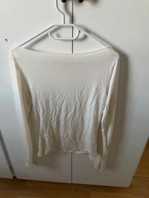 Vit långärmad topp i bomull - En enkel och stilren vit långärmad topp i mjuk bomull. Toppen har en rund halsringning och är figurnära i modellen. Perfekt att styla med jeans eller kjol för en clean look. Likar Intimissmi tröjorna.