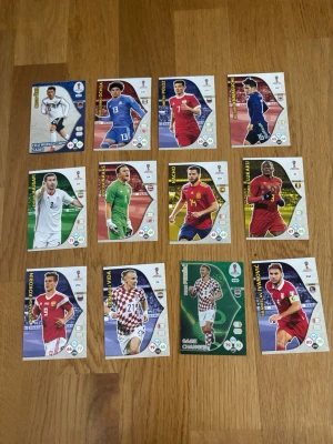 Panini Adrenalyn XL VM 2018 samlarkort - Ett set med officiella Panini Adrenalyn XL samlarkort från FIFA World Cup Russia 2018. Korten har färgstarka motiv av olika fotbollsspelare och nationer, med detaljerade stats och design. Perfekt för dig som gillar fotboll och vill bygga din egen samling. Skicka för mer information!