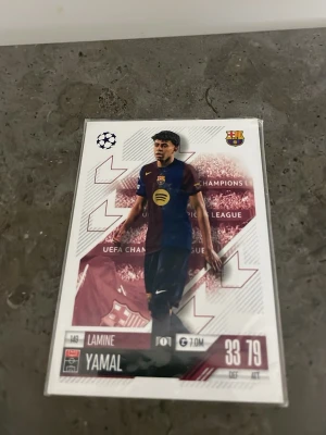 Match Attax Lamine Yamal samlarkort - Samlarkort från Topps Match Attax med Lamine Yamal från FC Barcelona. Kortet har Champions League-tema och visar spelaren i Barcelonas matchställ. Baksidan har FC Barcelonas logga och Match Attax-design. Perfekt för dig som gillar fotboll och att samla på kort.