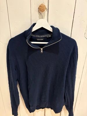 Mörkblå halvzip-tröja Jack & Jones - Mörkblå långärmad tröja från Jack & Jones med halv dragkedja vid kragen. 
