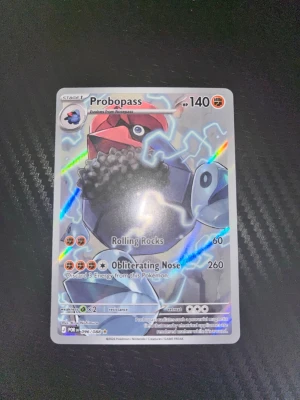 Pokémonkort Probopass holo - Säljer ett holografiskt Pokémonkort med Probopass från Sword & Shield-serien. Kortet har färger i rött, blått, grått och svart med glittrande detaljer. Perfekt för samlare eller Pokémonfans som vill utöka sin kortsamling.