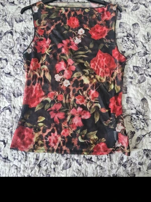 Blommig ärmlös topp (genomskinlig) - Snygg ärmlös topp med blommigt och leopardmönster i rött, grönt och svart. Tunn och lätt, perfekt för en trendig look. 