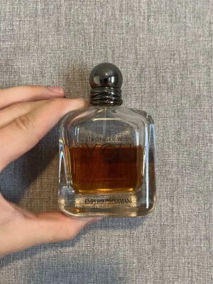 Emporio Armani Stronger With You parfym - Emporio Armani Stronger With You är en elegant parfym i en genomskinlig glasflaska med rundade kanter och mörkgrå metallkork. Doften har en varm bärnstensfärgad vätska och flaskan har en stilren, modern design som passar perfekt på parfymhyllan. Cirka 60ml kvar