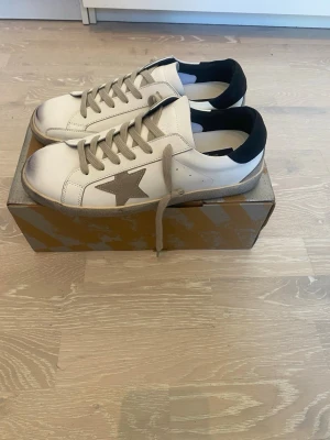 Vita sneakers med grå stjärna - Tja! Säljer ett helt par nya Golden Goose storlek 44.         Helt fleck fria och har inga som helst skador.                     Priset kan diskuteras och jag skickar inom 24 Tim💨☺️