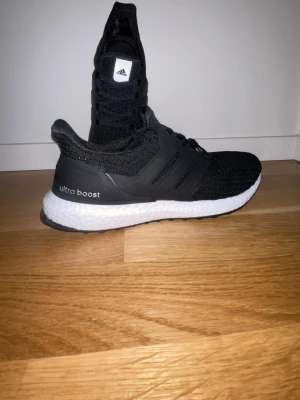 Svarta Adidas Ultra Boost sneakers - Svarta Adidas Ultra Boost sneakers med stickad ovandel och vita Boost-sulor. Box kommer med men den är lite sönder 