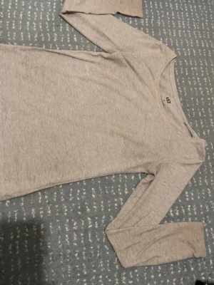 Ljusgrå långärmad topp från 157 - En enkel och stilren ljusgrå långärmad topp från 157. Perfekt basplagg med rund halsringning och smal passform.