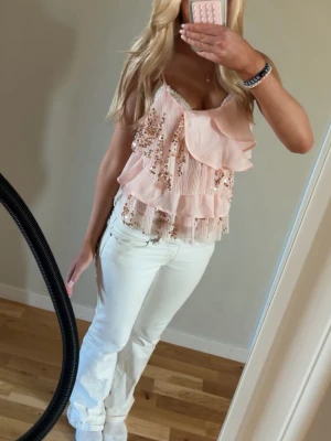 Rosa paljettopp med volanger💕 - Supersöt rosa linnetopp med paljetter och volangdetaljer. Toppen är ärmlös och har tunna axelband, perfekt för sommarens alla tillfällen. Materialet känns lätt och luftigt, och toppen har en croppad passform som ger en trendig vibe.💕 Helt ny knappast använt 