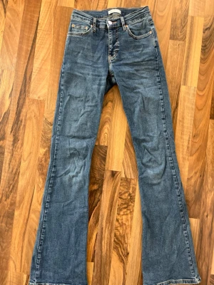 TALL mörkblå bootcut jeans  - Säljer ett par mörkblå bootcut jeans i modell TALL från Gina Tricot som är low/mid-rised. Använt ett fåtal gånger. De är väldigt stretchiga och är i storlek 34.