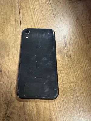 Svart iPhone med glasbaksida - Säljer en svart iPhone med stilren design och rundade hörn. Baksidan är i glas och mobilen har en enkel kamera med blixt. Klassisk Apple-logga på baksidan. Perfekt för dig som gillar snygg och enkel teknik.