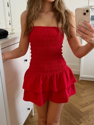 Röd axelbandslös volangklänning - Världens sötaste korta röda klänning!! Perfekt inför sommaren🤩 Storleken är S men passar även som XS. Bara använd en gång🤍