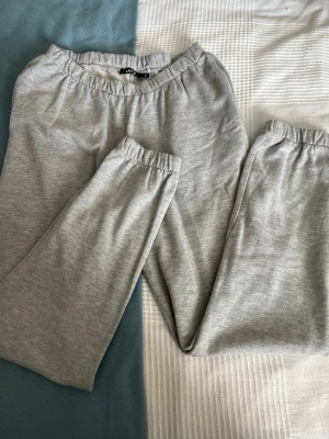 Grå mjukisbyxor från LMTD - Säljer ett par ljusgrå mjukisbyxor från LMTD i storlek M. Byxorna har resår i midjan och bensluten för extra komfort. Tillverkade i mjukt och skönt material, perfekta för chill dagar hemma eller när du vill vara bekväm.