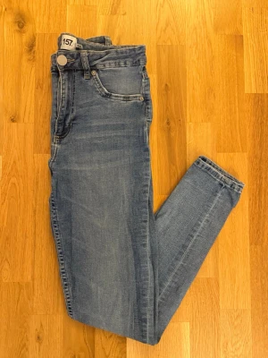 Ljusblå snake jeans från 157, storlek L - Snygga ljusblå jeans från 157 med klassisk femficksdesign och normalhög midja. Jeansen har en ljus tvätt och smala ben, perfekta för en avslappnad och trendig stil. Tillverkade i mjukt denimtyg för skön komfort. Storlek L. 