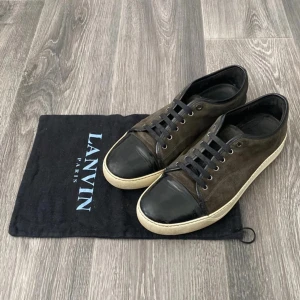 Svarta Lanvin Skor - Snygga sneakers från Lanvin i svart mocka med svarta läderdetaljer. Perfekta för dig som gillar stilrena och exklusiva sneakers med lyxig känsla. 