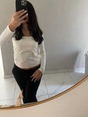 Vit långärmad topp - Säljer en enkel och stilren vit långärmad topp. Toppen har en rund halsringning och är mjuk och bekväm. Använd 2 gånger, säljer pga att den är för stor.