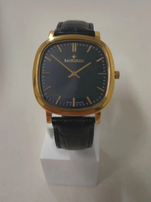 Herr Morris Armbandsur - Klassisk Morris armbandsur med svart urtavla och guldfärgad boett. Klockan har ett svart läderarmband.  Orginal kartong medföljer om man vill men kartongen är väldigt missfärgad pågrund av att kartongen har legat en längre period i solen  Så man vet om det bara  Vid mer frågor eller bilder skriv gärna isåfall   OBS FINNS UTE PÅ FLER SIDOR skriv innan köp så den inte är såld