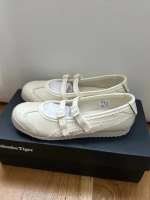 Krämvita ballerinaskor Onitsuka Tiger - Onitsuka Tiger Mexico 66 TGRS - Ballerinaskor med remmar i färgen ivory cream Stl 35.5  Helt oanvända och kommer i sin orginalbox