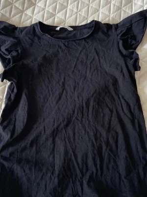 Svart topp med volangärmar från mango - En svart topp från mango med volangdetaljer på ärmarna. Perfekt nu inför vår och sommar. Pris går att diskutera🙂