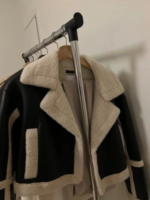 faux leather jacket  - Snygg svart teddyjacka med vita, fluffiga detaljer och bred krage cropped jacka. oanvänd,som ny. priset kan diskuteras nypris är 999kr 