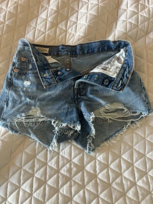 Blåa jeansshorts Levi's - Säljer ett par blåa jeansshorts från Levi's med slitna detaljer. Perfekta inför sommaren. Osäker på storlek men passar mig som har storlek xs. Aldrig använda. Pris går att diskutera💞
