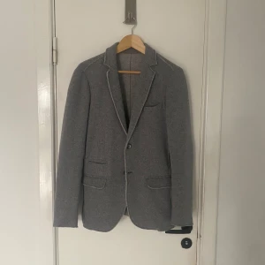 Grå stickad kavaj från Zara Man - Säljer en riktigt schysst stickad kavaj från Zara Man. Funkat vid både avslappnade och uppklädda tillfällen. Den är även i ett väldigt skönt material. I storleken M 