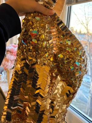 Guldig glittrig långklänning oneshoulder - Beställd från USA och är använd 1 gång. Kostade 7000kr sammanlagt med tull att köpa in. Passar som balklänning eller till ett bröllop! 