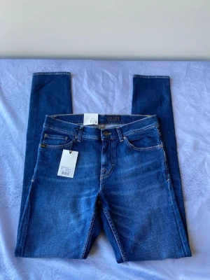 Tiger of sweden jeans - w29/L34 - Säljer ett par klassiska blå slim jeans från tiger of sweden  med fem fickor och snygga kontrastsömmar. Jeansen har normal midja och är tillverkade i stretchigt denim för en bekväm passform. Perfekta till vardagslooken och lätta att matcha med olika stilar.