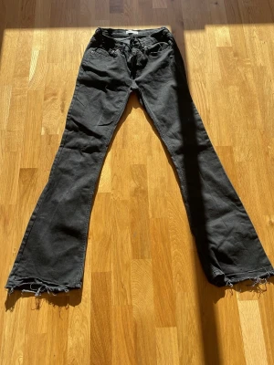 FRI FRAKT JUST NU - Svarta lågmidjade bootcut jeans med uppdragen kant - Säljer ett par svarta bootcut jeans med uppdragen kant så dom ska bli längre. Jeansen har klassisk femficksmodell och är lågmidjade. Perfekta för dig som gillar en avslappnad och trendig stil.