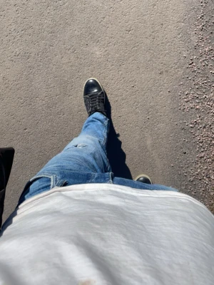 Blå  jeans Jack & Jones - Säljer ett par blå skinny fit jeans från Jack & Jones, modell Liam. Jeansen har slitningar och hål för en trendig look. Klassisk femficksmodell med dragkedja och knapp. Perfekta för dig som gillar en smal passform och streetstil.