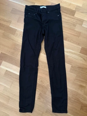 Svarta skinny jeans Molly M - Svarta skinny jeans från Gina Tricot, modell Molly. Jeansen har klassisk femficksdesign, hällor för skärp och är tillverkade i stretchigt material för en tight passform. Perfekta för en trendig och bekväm look. Låg midja, aldrig använda 