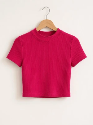 Ribbad rosa croppad topp - Trendig ribbad croppad topp i stark rosa färg med korta ärmar och högre rund halsringning. Tillverkad i stretchig polyesterblandning som sitter snyggt på kroppen. Perfekt för att lyfta vilken outfit som helst.