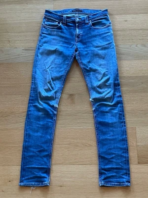 Nudie Jeans - Säljer ett par blåa Nudies. De har riktigt snygga fades och har uppenbarligen hängt med ett bra tag. Lappen sitter inte kvar men jeansen sitter definitivt som slim fit. De har tyvärr ett par hål, men går såklart att laga antingen själv eller gratis i en av Nudies butiker. Storleken är W29 L34. Hör av er vid funderingar🙏