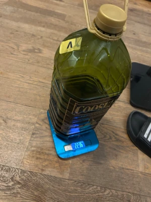 Coosur olivolja 2,2 dunk - Stor plastdunk med 2,2 liter Coosur Serie Oro extra jungfruolivolja. Flaskan är grön och har ett praktiskt handtag upptill. Perfekt för matlagning och sallader. Etiketten är svart med guldiga detaljer och olivmotiv.