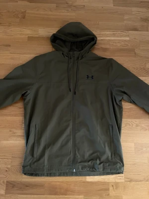 Olivgrön vindjacka från Under Armour - Säljer en ny Under Armour jacka, Aldrig använt den!