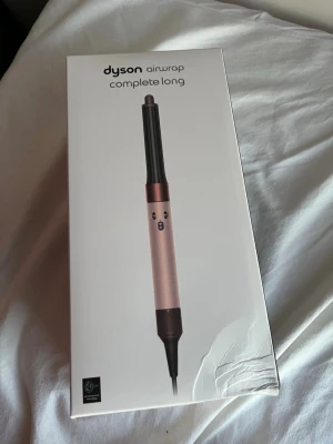 Dyson Airwrap Complete Long hårstyler - Säljer en Dyson Airwrap Complete Long i snygg roséguld och svart design. Den kommer i originalförpackning med tillhörande svart förvaringsbox. Perfekt för att styla och forma håret med avancerad teknik och flera tillbehör.