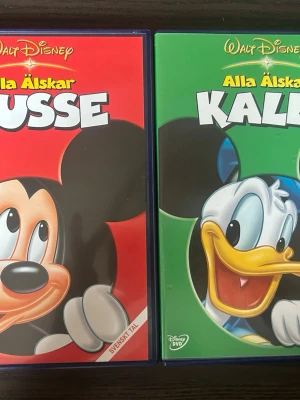 Alla älskar Musse & Alla älskar Kalle dvd - Två DVD-filmer med Disney-klassiker. "Alla älskar Musse" innehåller kortfilmer med Musse Pigg. "Alla älskar Kalle" innehåller kortfilmer med Kalle Anka.   Båda filmerna har språk: Svenska, Danska, Norska, Finska, Engelska, Portugisiska   OBS!! skivorna är begagnade så det kan förekomma repor/hairlines på skivorna, men då jag kollar igenom alla filmer jag säljer garanterar jag att alla funkar felfritt om inget annat står! :)