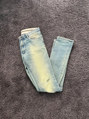 Unika jeans med slitningar  - Väldigt unika jeans med slitningar, färgen är lite off i bilderna, mer blåa irl. Sitter slim men lite flared på botten alltså blir de perfekt till boots. Storlek W29 L34