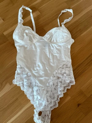 Vit body med spetsdetaljer - Snygg vit satin body med spetsdetaljer. Perfekt till sommarkvällar! Använd 1 gång☀️