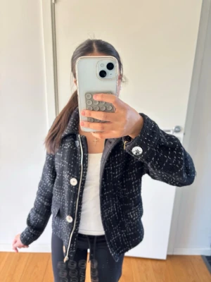 Svart rutig bomberjacka med knappar - Snygg svart bomberjacka med vitt rutmönster och stora silvriga knappar framtill. Jackan har krage och två fickor på sidorna. Priset går att diskuteras! 🛍️👏
