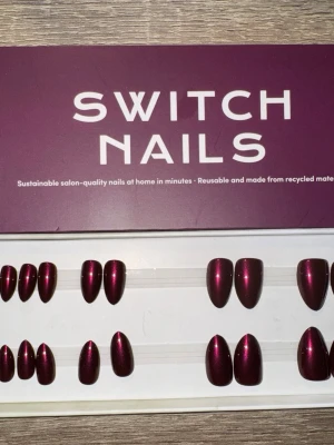 Switch Nails Cherry Noir press-on - Snygga press-on naglar från Switch Nails i modellen Cherry Noir. Färgen är en djup körsbärsröd med glansig finish. Formen är almond short, vilket ger en elegant och modern look. Naglarna är återanvändbara och tillverkade av återvunnet material. Säljes utan tillbehör.