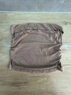 Beige ribbad tubscarf - En beige tubscarf i ribbat tyg, perfekt att styla till olika outfits. Mjuk och stretchig, enkel att dra över huvudet. Passar både som halsvärmare och accessoar.