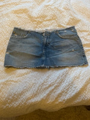 Blå jeanskjol med rå kant - Säljer min fina jeanskjol som är perfekt till sommaren. Den är perfekt i längden för mig som är 157!