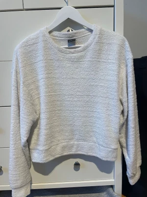 Vit tröja - Vit tröja med lite fluffigt tyg. Har en lösare passform och passar S/M. 