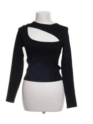 Svart croppad topp med cut out - Snygg svart croppad topp med lång ärm och unik cut out-detalj över bröstet. Toppen har en tight passform och är perfekt för dig som vill sticka ut. Tillverkad i mjukt stretchigt material som sitter skönt på kroppen.