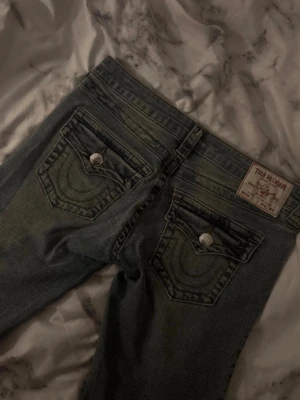 True Religion  - Säljer snygga true religion jeans! 💞 De är uppklippta nere vid benen men inget som man märker så väl😊 Aldrig använt de själv men köpte dem begangnat‼️ Storlek 26, de är blåa med fint material 🦋 PRIS KAN DISKUTERAS🚨‼️ 💐 ställ gärna mer frågor vid intresse 💲🙏🌺