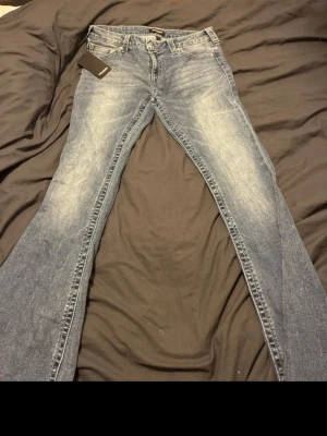 Blå bootcut jeans från True Religion - Pris kan alltid diskuteras 💕 Säljer ett par blå jeans från True Religion med klassiska kontrastsömmar och ikoniska bakfickor. Modellen har bootcut-ben och normal passform. Jeansen har en snygg tvättad look och är tillverkade i slitstarkt bomullsmaterial. Märkeslapp bak och originaltag kvar. Säljer även dom på vinted. 
