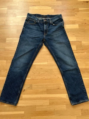 Nudie Jeans Gritty Jackson - Säljer ett par mörkblå Nudie jeans Gritty Jackson i strl W31 L30. Jeansen har en straight fit passform och är helt oanvända.
